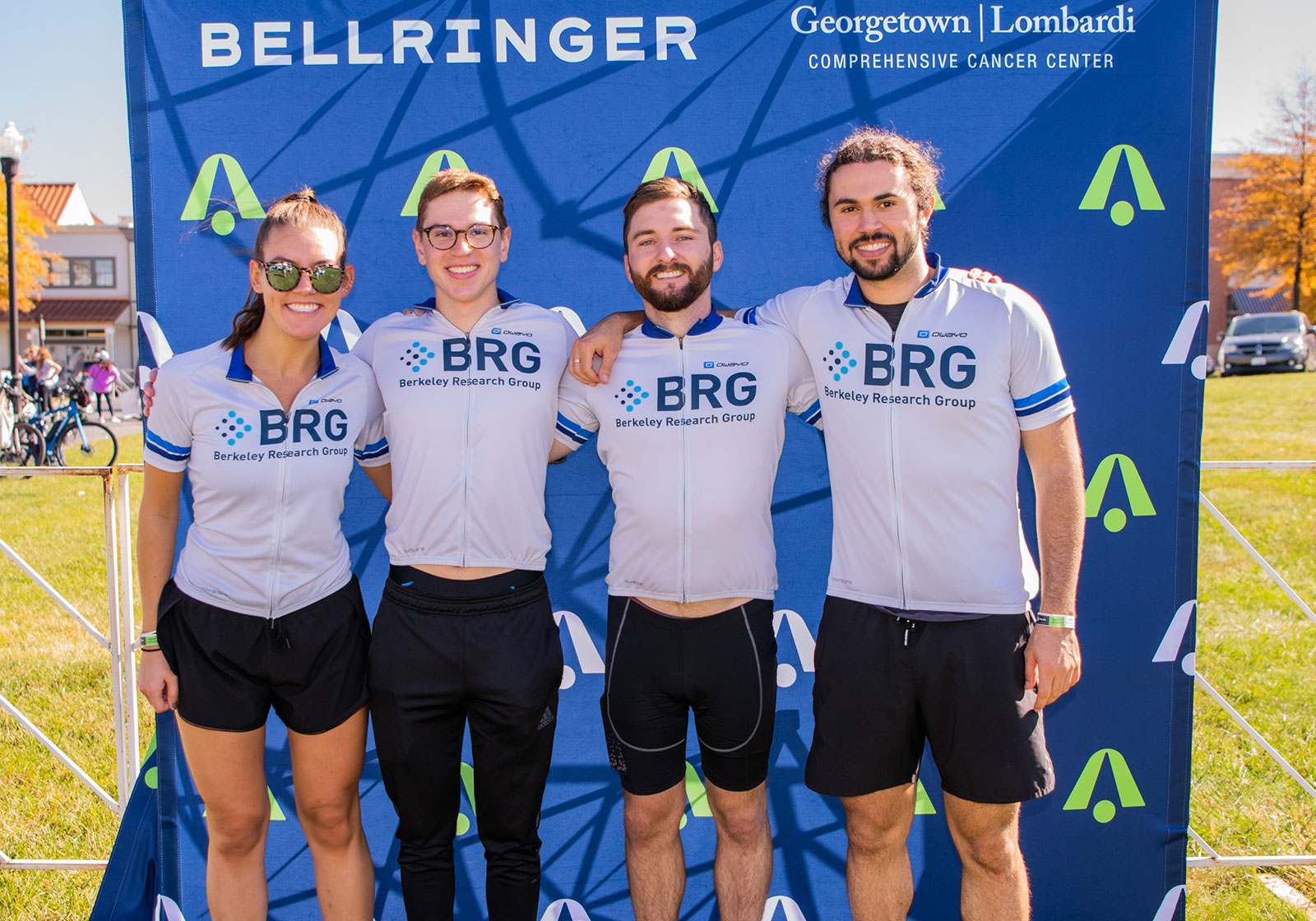 BellRinger riders in front of bell logo sign at 50/100 mile finish in Urbana, MD