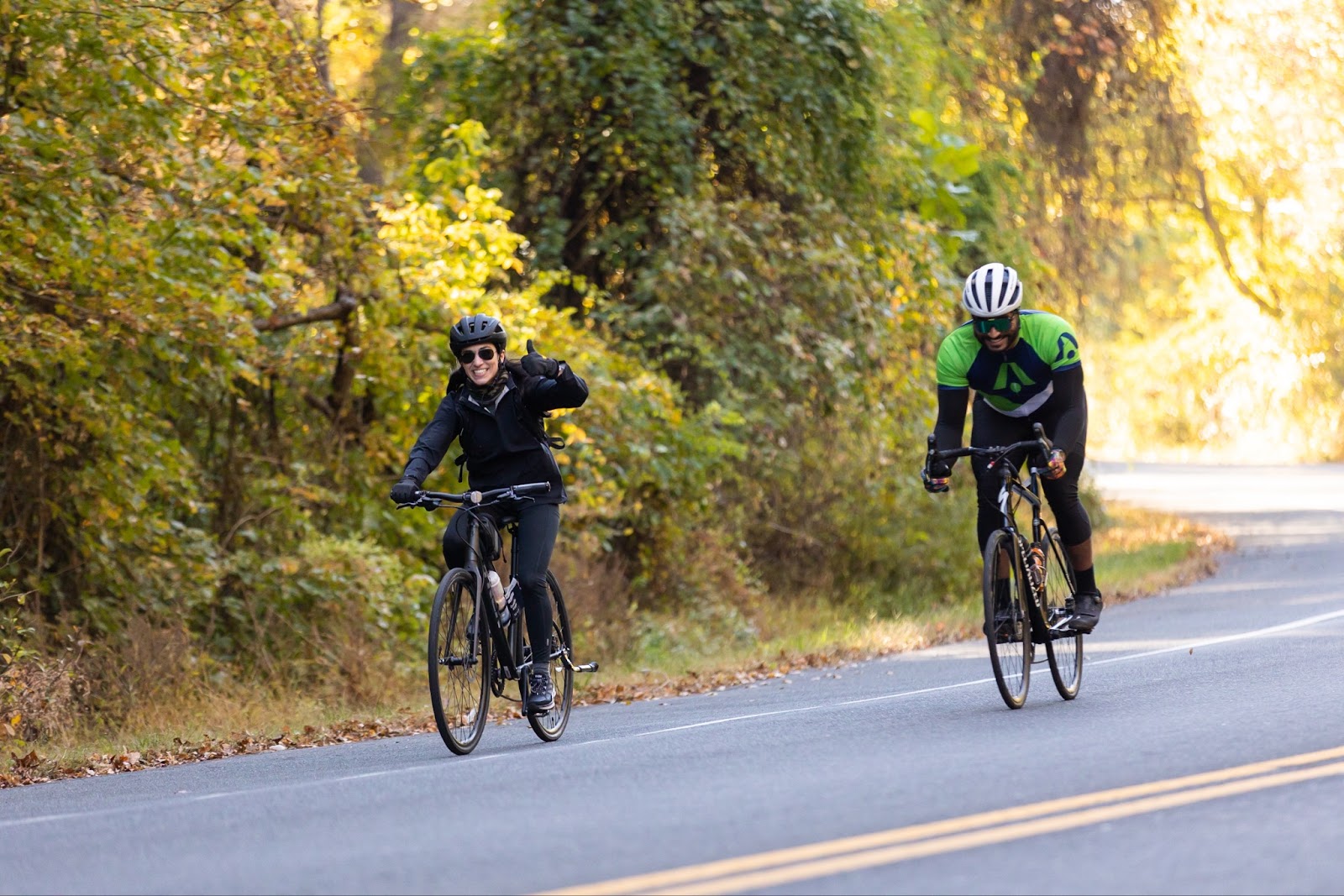 Two BellRinger riders riding their bikes on a scenic road smiling