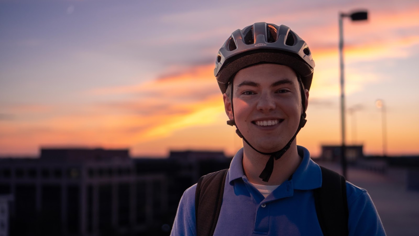 BellRinger rider smiling in a bike helmet at sunrise