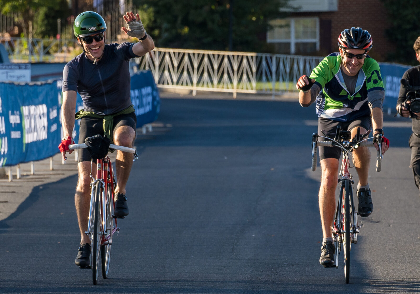 Two BellRinger riders crossing the finish line and waving