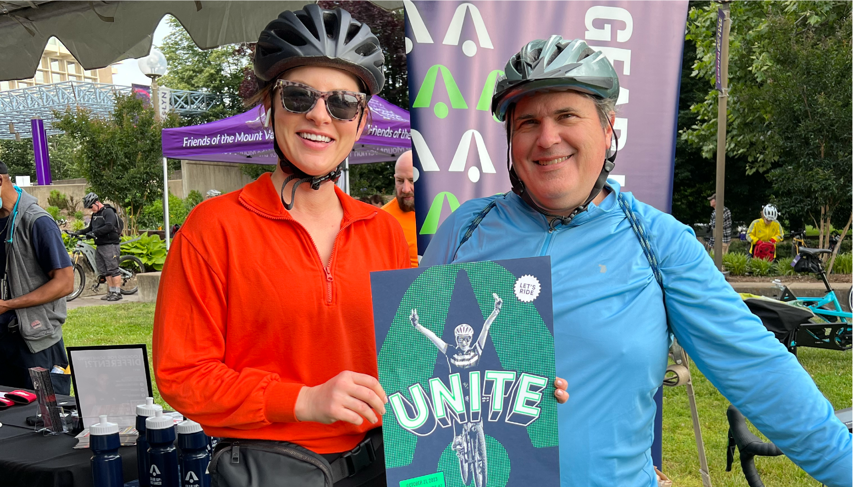 Two BellRinger riders posing with a unite poster